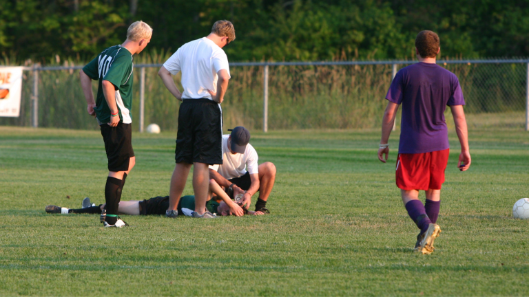 soccer player suffering from concussion symptoms on field