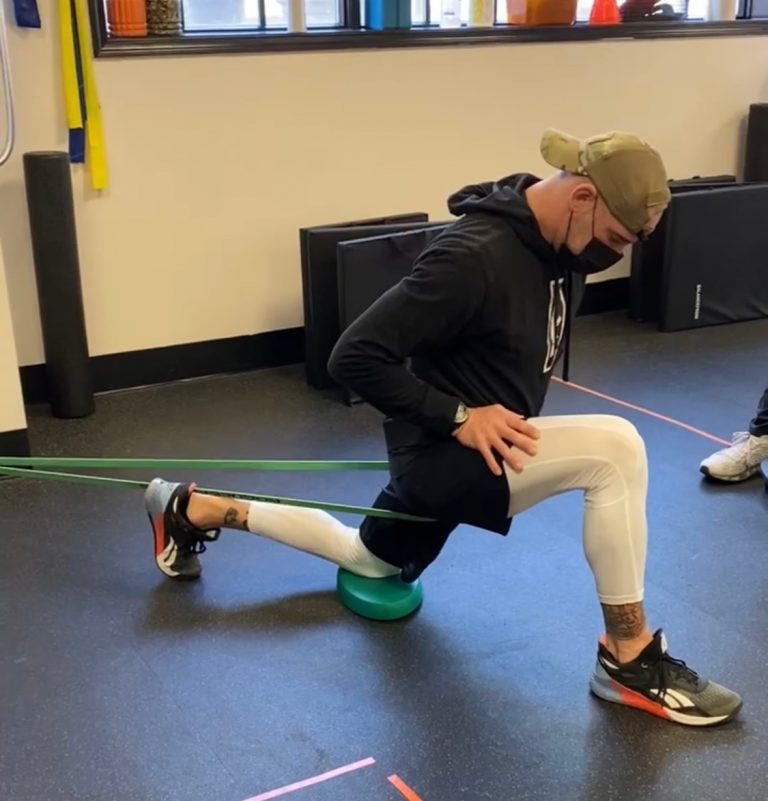 chiropractor helping teach patient how to stretch it band